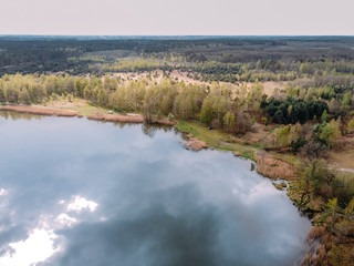 aerial photography of a forest lake with reflected clouds