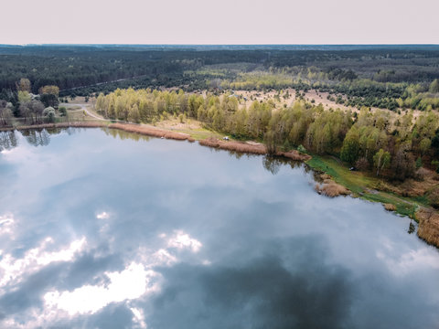 aerial photography of a forest lake with reflected clouds