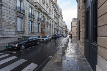 Paris, France. Europe - November 2, 2018: Street scene in Paris with bicycle rider and wet street
