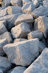 Close up. rock stone breakwater at the pier on the beach.