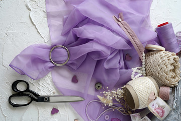 Stylish concept of sewing business. Scissors, lace, threads, fabric, coils, reel, lock, buckle on...