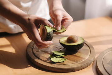 Middle selection of female pill an avocado on wooden board at home. Vegetarian food concept