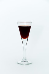Small glass with red wine on a white background
