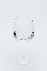 Glass with transparent water on a white background.