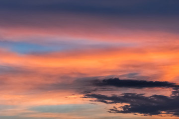 Colorful sunset on a beautiful summer sky with dark evening clouds after rain