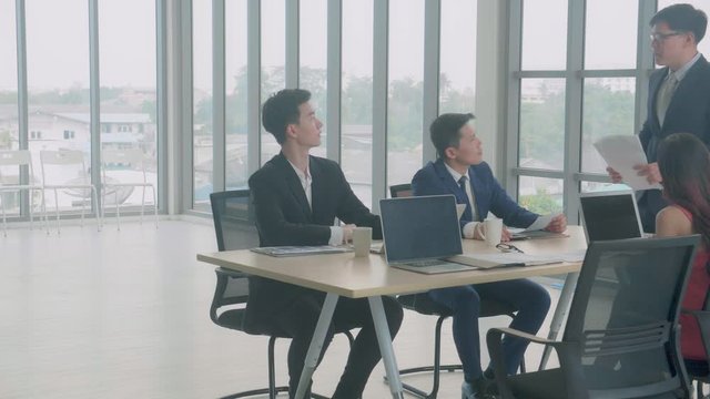 Business group meeting with manager giving handout document report with employee, leadership and executive, collaboration of partner, businessman presentation or briefing of project with colleague.