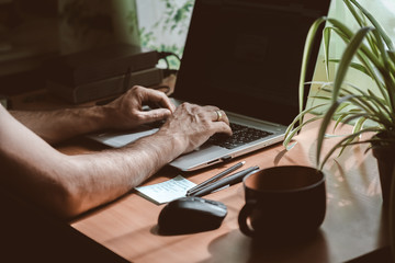 A man with a laptop works in a home office during quarantine. Working in self-isolation concept