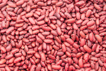 Red beans on fruit vegetables street market pattern as background, close up photo