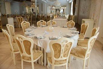 White table with plates knives, forks and napkins.