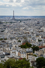 Paris skyline, view from the Sacre Coeur on Montmartre hill, France. Basilica of Sacre Coeur is one of the landmarks in Paris. Aerial view of Paris in summer. Panorama of Paris city on a cloudy day.