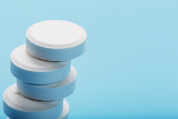 Tower of Medicinal tablets on a blue background, isolated.