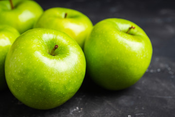Close-up green apples on the rustic wooden background. Selective focus. Shallow depth of field.