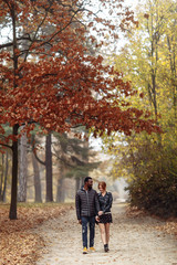 Fototapeta premium Happy interracial couple walking in autumn park