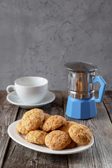 Oatmeal cookies with a coffee pot and a white cup. On a wooden background.