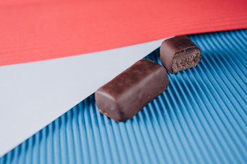 the candy is placed on an abstract background of red, blue and white sheets of paper