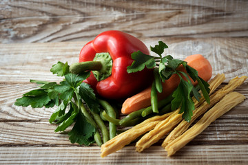 fresh vegetables and herbs on a wooden background. red sweet peppers, asparagus, beans, carrots