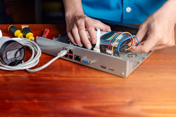 Technician remove a hard disk drive from the CCTV DVR recorder case , to install a new hard drive...