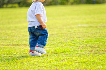 The little boy in a hat in the outdoor lawn
