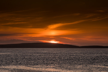 cielo infuocato dal tramonto sulle isole Orcadi