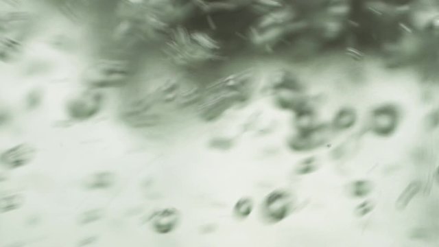 water is boiling in a glass kettle creating a whirlpool backlit close up macro.