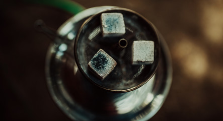 Shisha hookah with red hot coals. Sparks from breathe. Toned image. Modern hookah with coconut charcoal for relax and shisha smoke. Hookah and sparks from coals. from the top close up view
