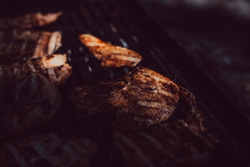 Racks of pork bbq ribs sitting on smoker grill with smoke coming from grill