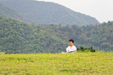 Fototapeta na wymiar A little boy sitting on the grass