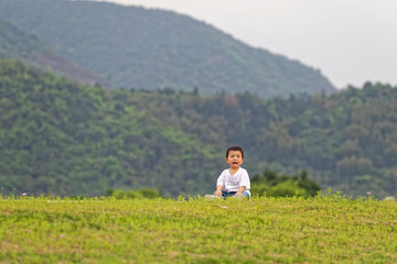 Fototapeta na wymiar A little boy sitting on the grass