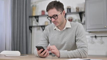 Young Man Using Smartphone, Browsing Internet