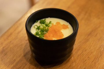 Bowl of Japanese steam egg on wooden table.