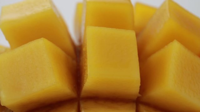 Ripe mango cube slice turning on white background, Mango juice and tropical fruit product concept.