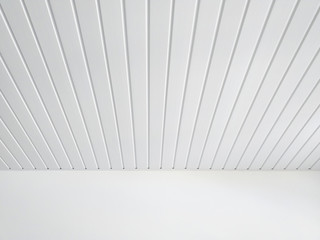 Perspective of white wood sheeting ceiling and smooth white wall in Caribbean construction. White...