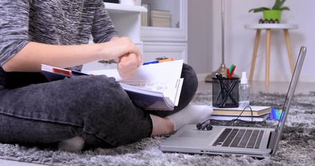 High school student girl using sanitizer before doing her homework. Online education during the coronavirus pandemic. Closeup 4k