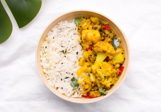Gobi aloo indian vegetarian dish of vegetables and potatoes in a bowl of bamboo on a white linen cloth