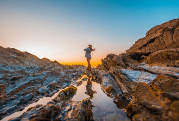 Obraz premium Lifestyle, a young businesswoman on the rocks by the sea