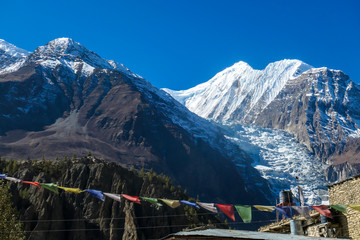 Fototapeta premium Harsh slopes of Manang Valley, Annapurna Circus Trek, Himalayas, Nepal, with the view on Annapurna Chain and Gangapurna. Dry and desolated landscape. High mountain peaks, covered with snow.