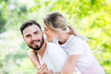 Happy young caucasian couple embracing together with passionate love in public park,Couple in love hugging and having romantic tender moments in the summer vacation.Lifestyle loving couple at nature.