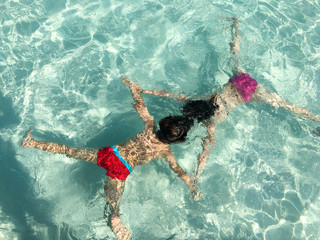 Children play in the pool underwater making the star