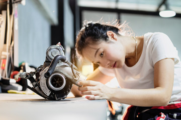 Mechanic woman try to fix used turbocharger in the garage