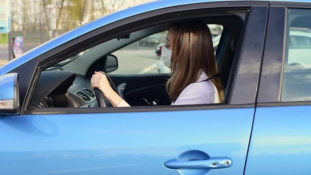 Woman in protective mask have fun in car at parking