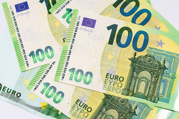 several banknotes of 100 euros close-up on a white background 
