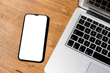 laptop and mobile phone on a brown desk