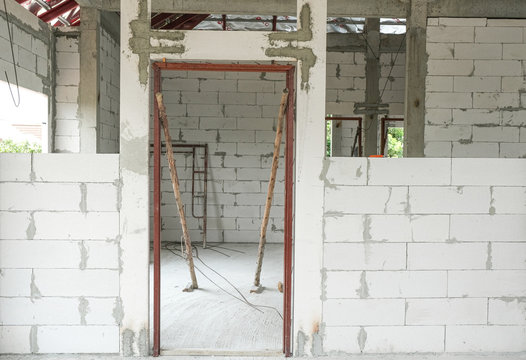 lightweight cement brick and white lintel plaster to joint for reinforce door in house construction site.
