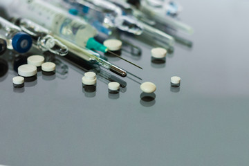 Thermometer, pills, injection vaccine ampoules, syringeon glass background, Coronavirus, MERS-CoV,...
