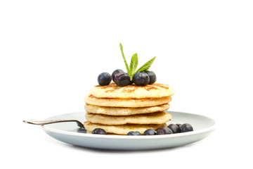 Tortitas con arándanos y hojas de menta sobre un plato gris sobre un fondo blanco aislado. Vista de frente. Copy space