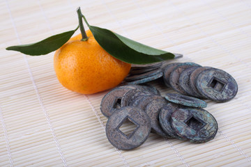 Mandarin oranges and ancient Chinese coins on bamboo background. Symbols of luck and Chinese New...