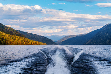 The wake of the stern of a motor boat sailing on a mountain lake. Fall. Russia, Altai Republic,...