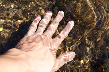 Hands touching the water of the river