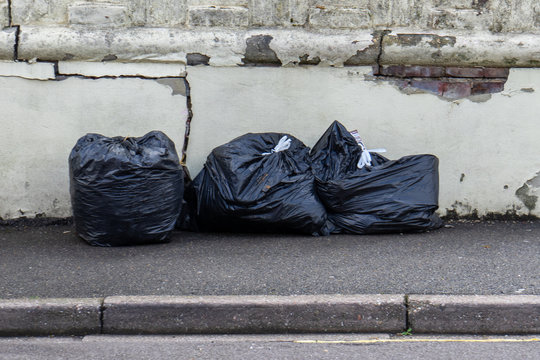 black bin bags full of rubbish on a street or pavement