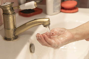 Washing hands under the faucet with water. Washing hands with soap and water. Hand hygiene concept